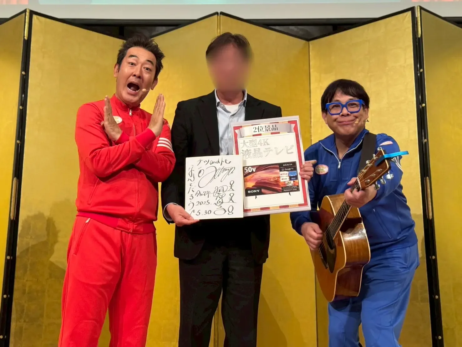 ビンゴ上位者にサイン入り色紙を手渡すテツandトモさん