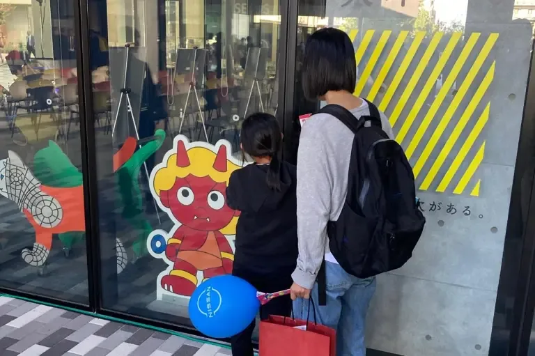 キャンパスのキャラクターと記念撮影をする来場者